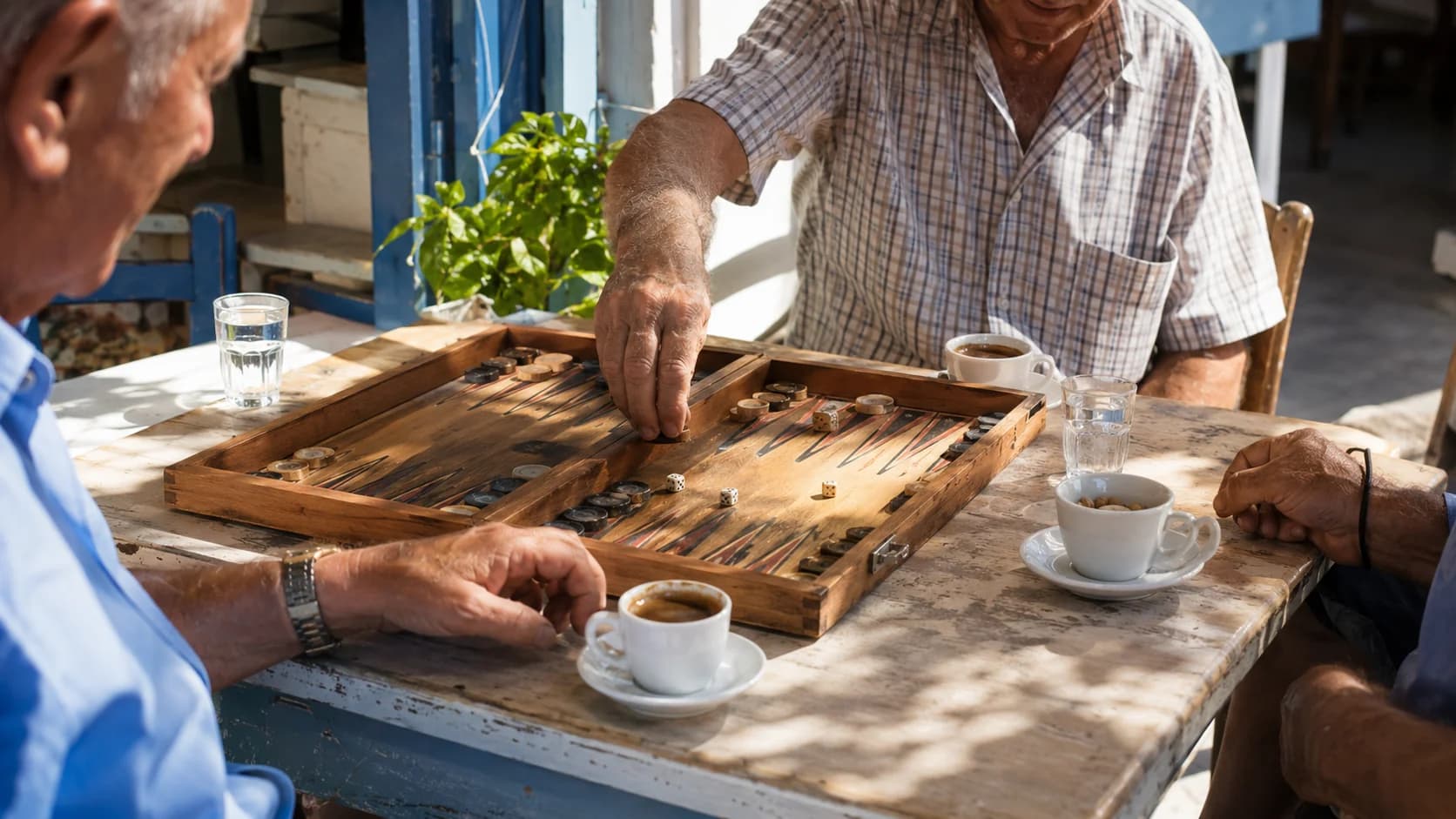 Greek coffee and water served beside a backgammon game at a traditional kafeneio