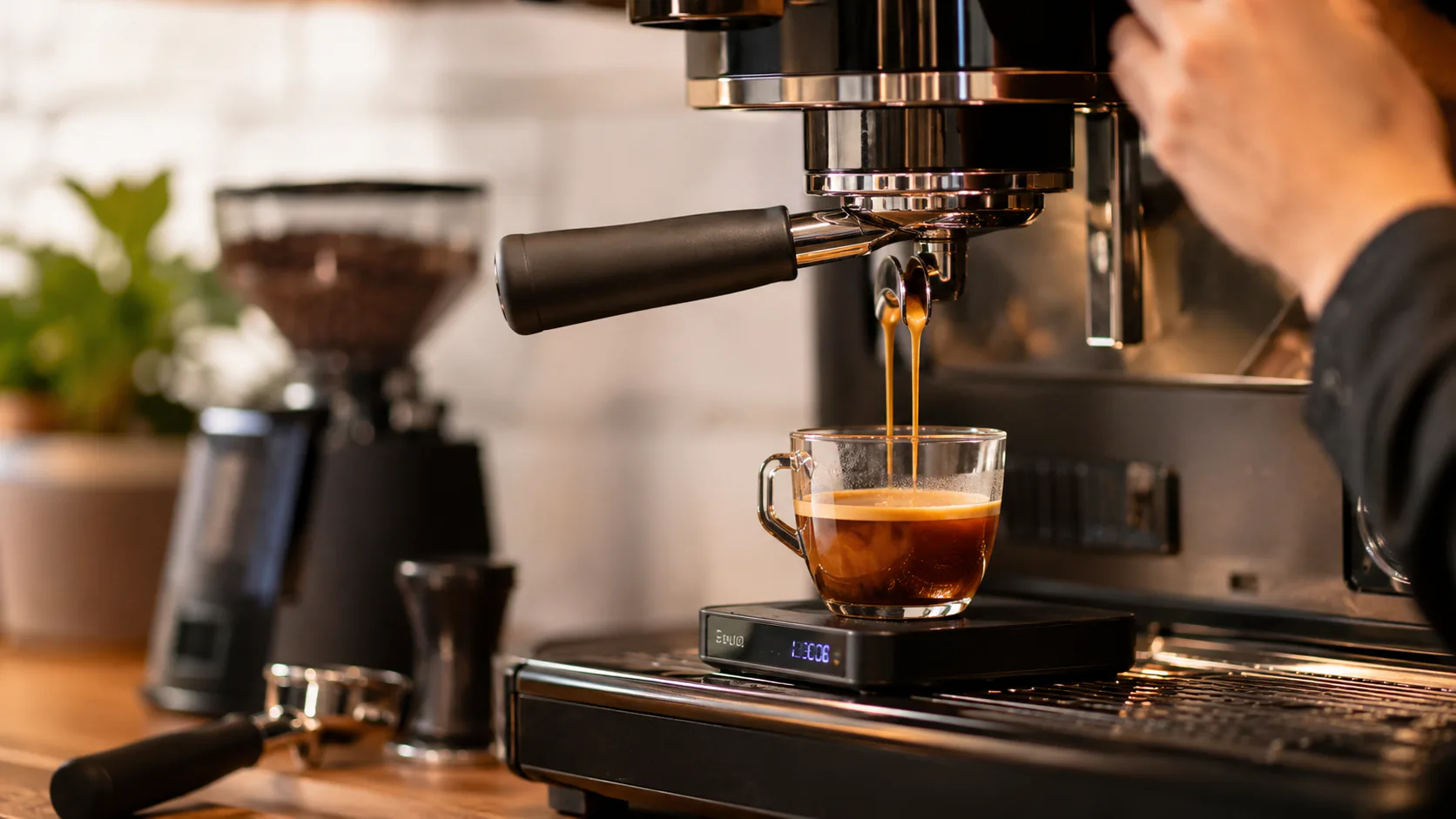 Allongé espresso extracting from an espresso machine into a glass cup on a scale