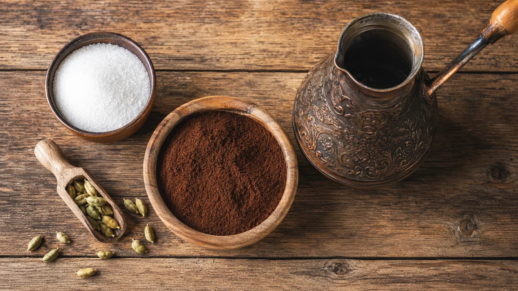 Armenian coffee ingredients with fine grounds, sugar, cardamom, and a copper jazzve