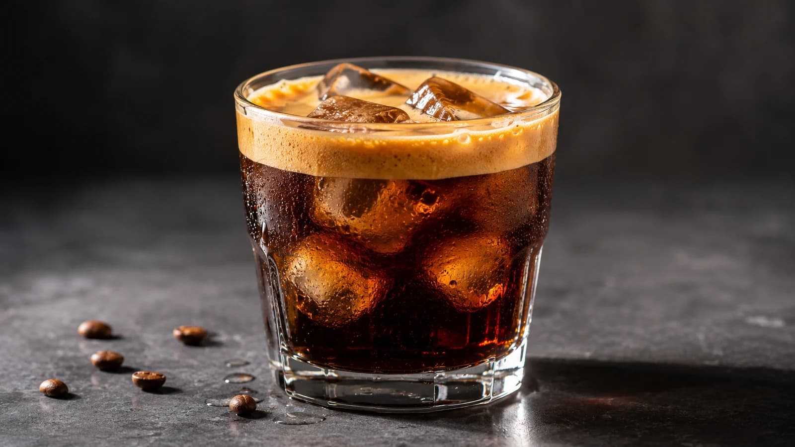Short iced long black with espresso crema floating over cold water and ice