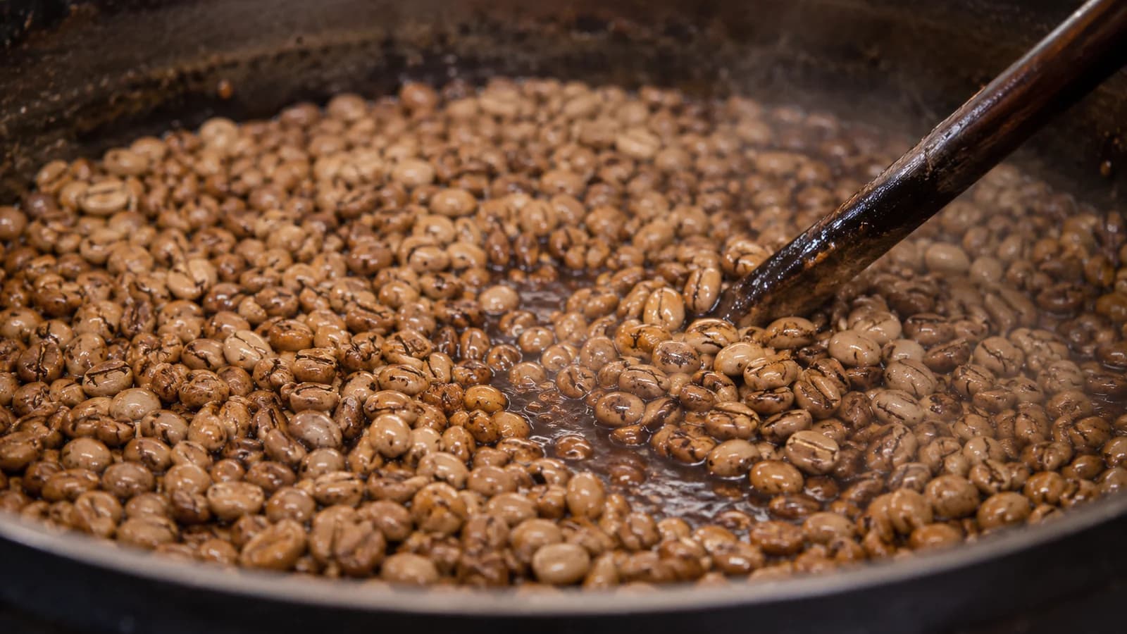 Ipoh white coffee beans roasting with palm-oil margarine in a pan