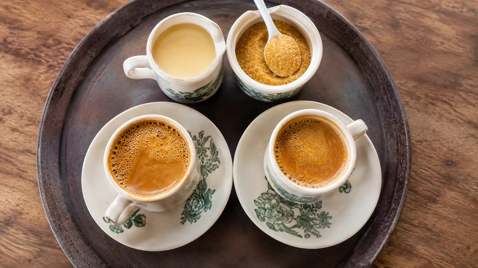 Kopi C ingredients with evaporated milk, sugar, and kopitiam cups on a tray
