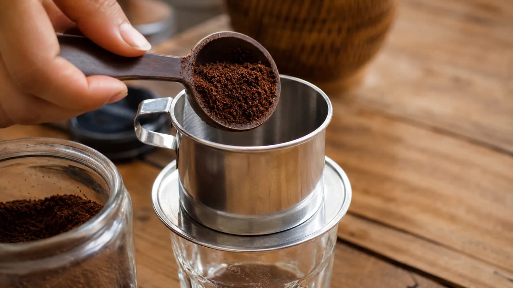 Vietnamese coffee brewing through a metal phin filter over a glass